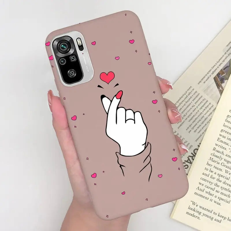 a woman holding a phone case with a heart on it