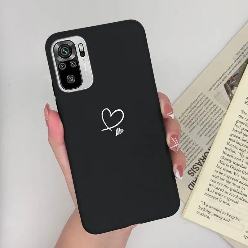 a woman holding a phone case with a heart on it