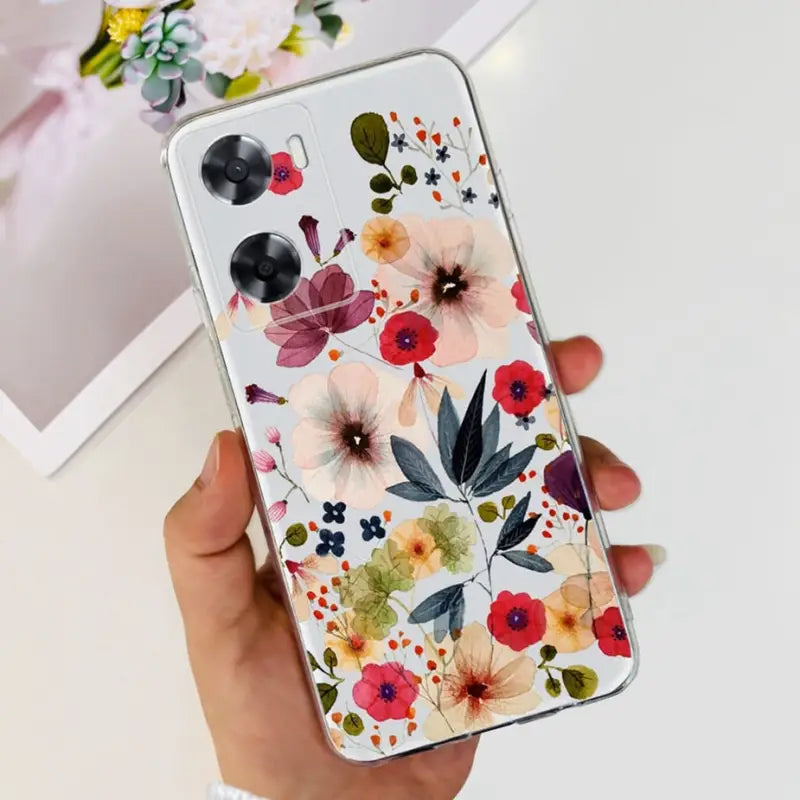 a woman holding a phone case with flowers on it