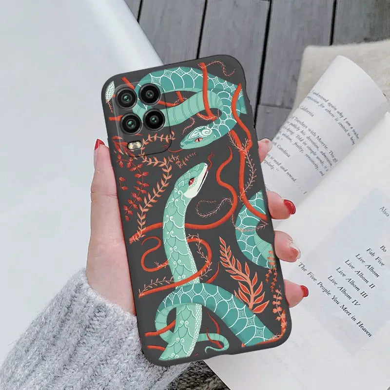 a woman holding a phone case with a green snake on it