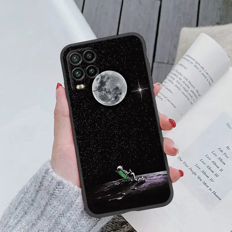 a woman holding a phone case with a moon on it