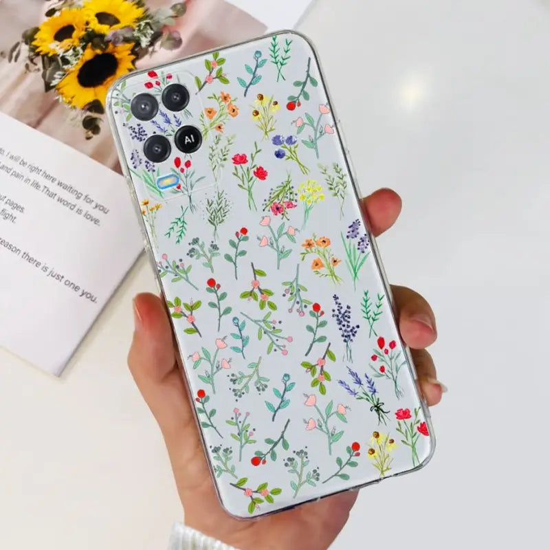 a woman holding a phone case with flowers on it