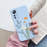 a woman holding a phone case with a flower design