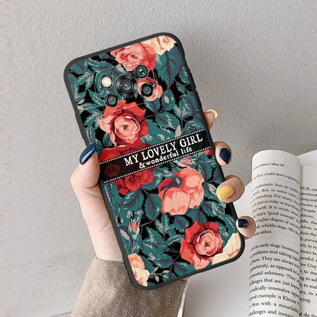 a woman holding a phone case with flowers on it