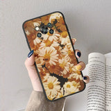 a woman holding a phone case with flowers on it