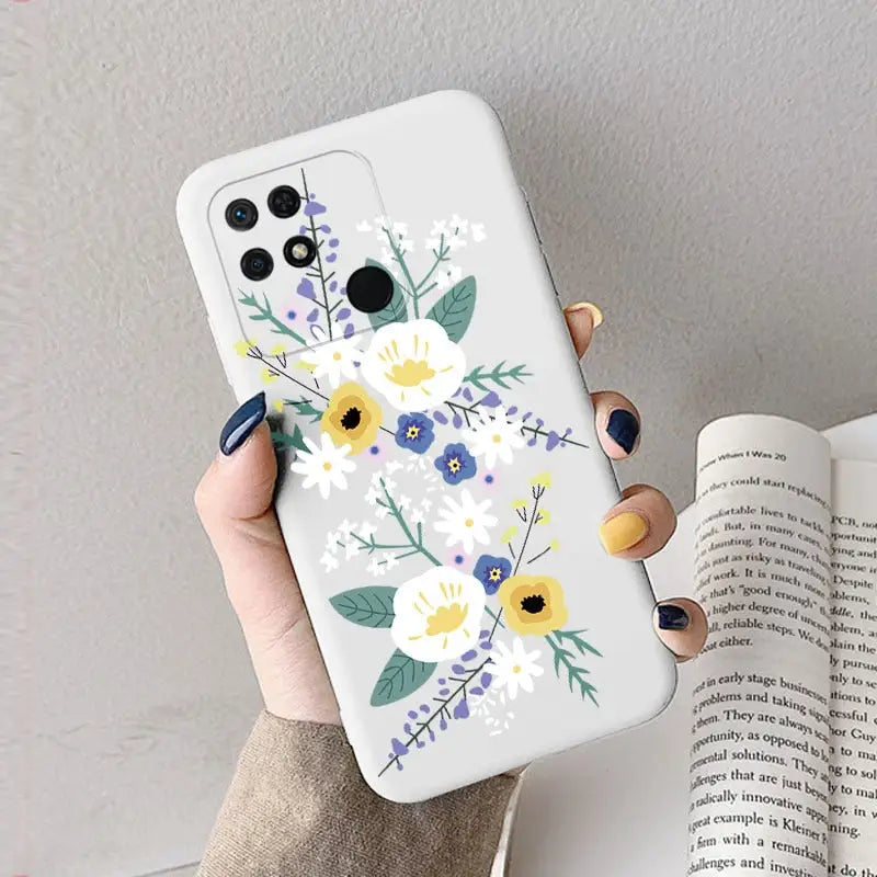 a woman holding a phone case with flowers on it