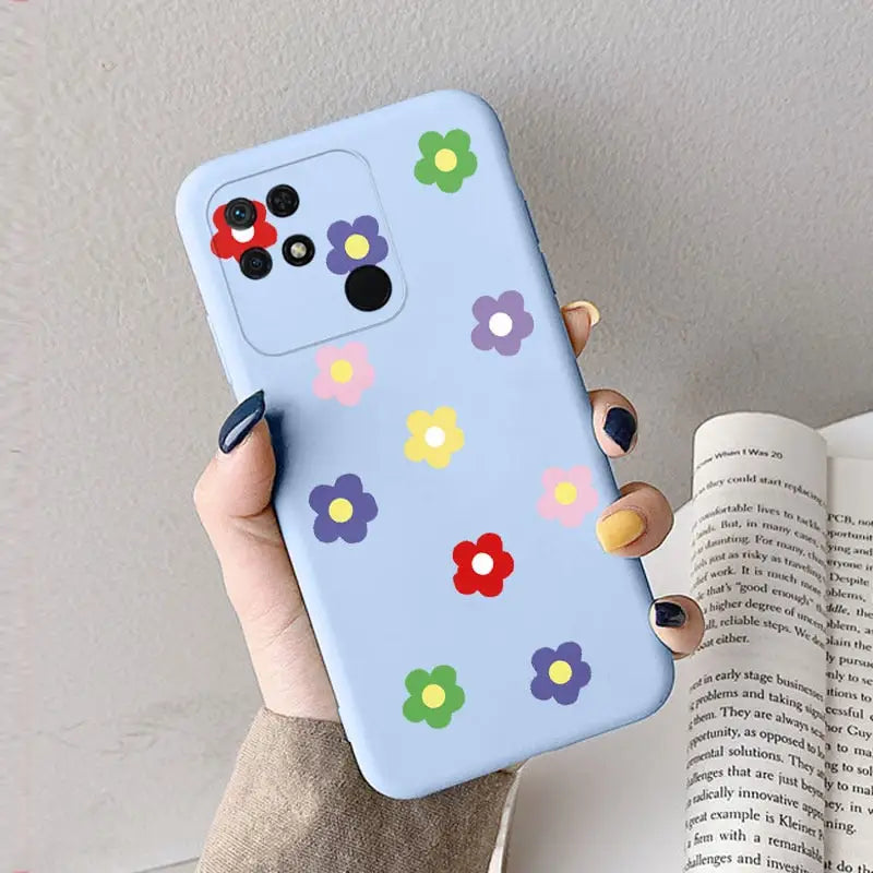 a woman holding a phone case with colorful flowers on it