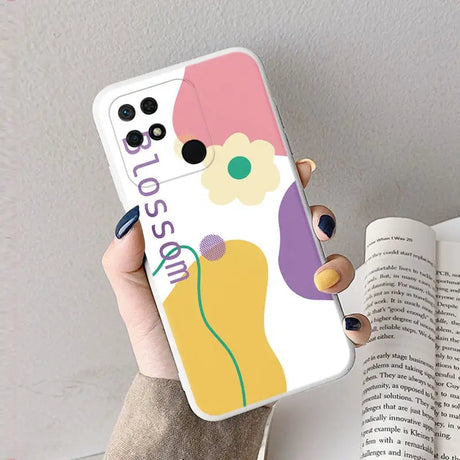 a woman holding a phone case with a colorful flower design