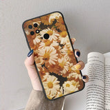 a woman holding a phone case with flowers on it