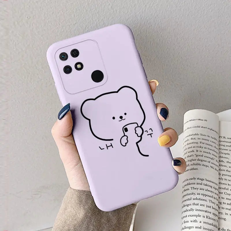 a woman holding a phone case with a drawing of a bear
