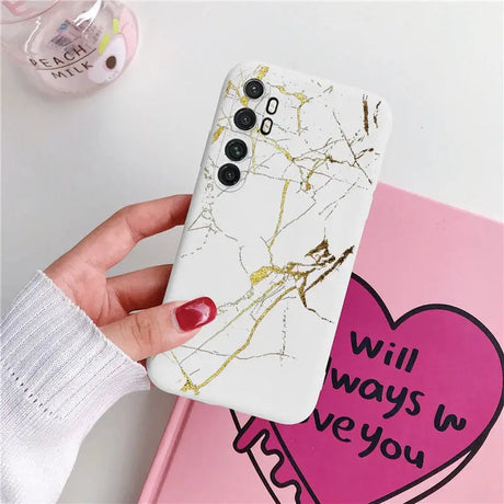 a woman holding a phone case with a heart on it