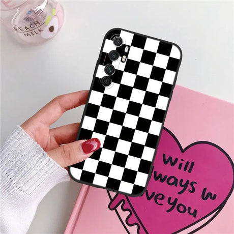 a woman holding a phone case with a heart on it