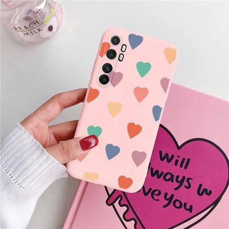 a woman holding a phone case with hearts on it