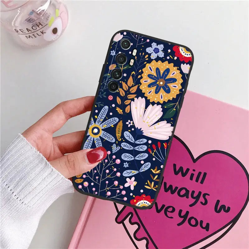 a woman holding a phone case with a heart and flowers