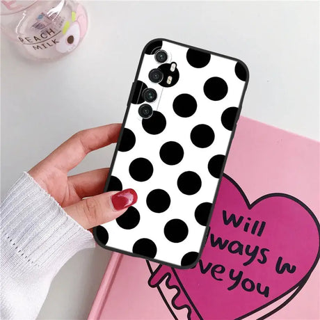 a woman holding a phone case with a heart on it