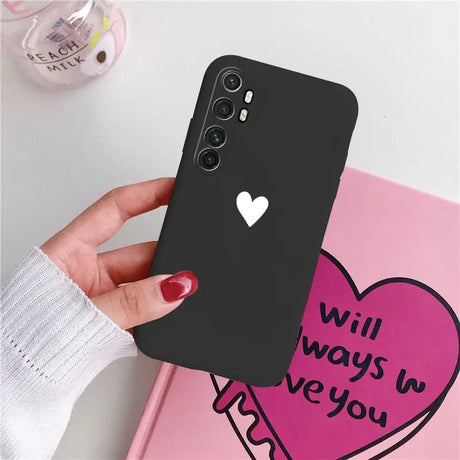 a woman holding a phone case with a heart