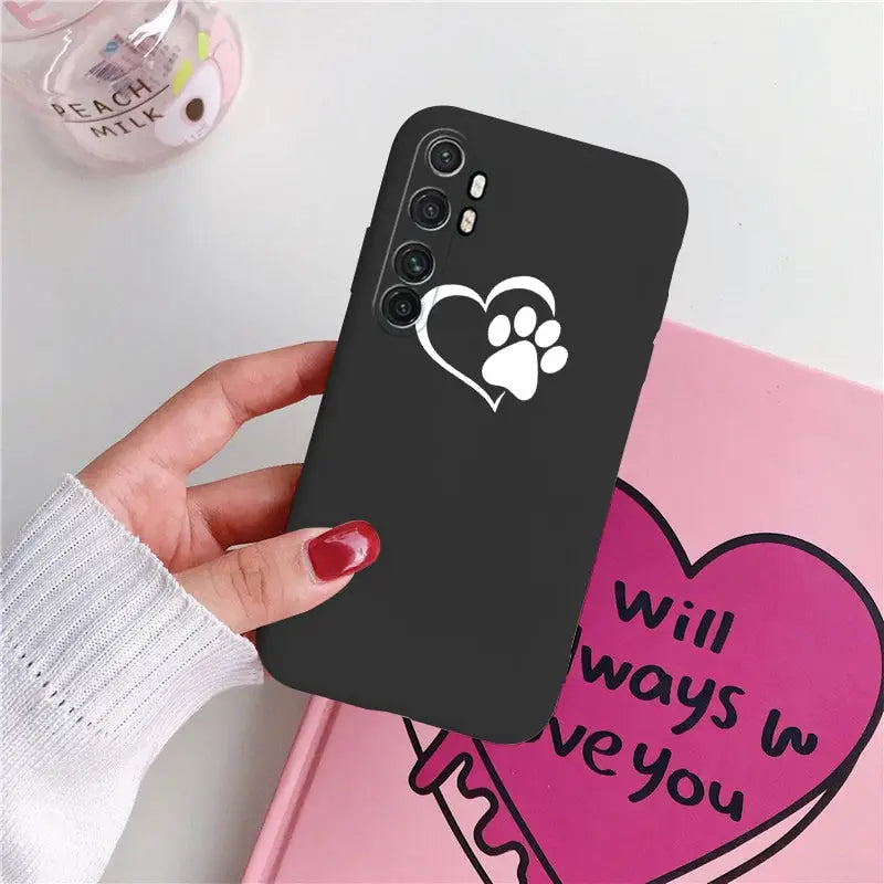 a woman holding a phone case with a heart and paw paw