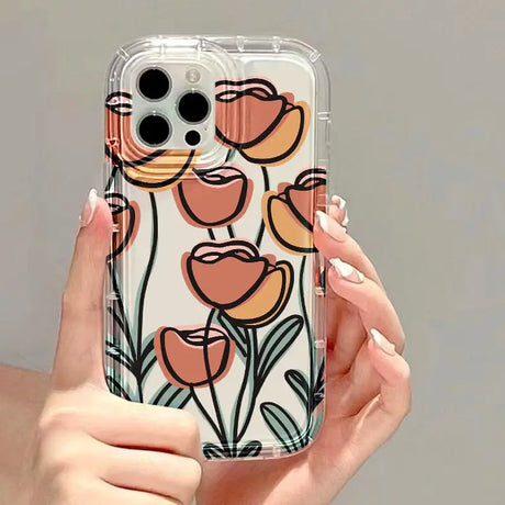 a woman holding a phone case with flowers on it