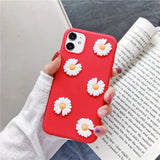 a woman holding a red phone case with white flowers on it