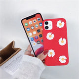 a person holding a red phone case with white flowers