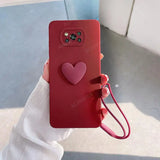 a woman holding a red phone case with a heart on it
