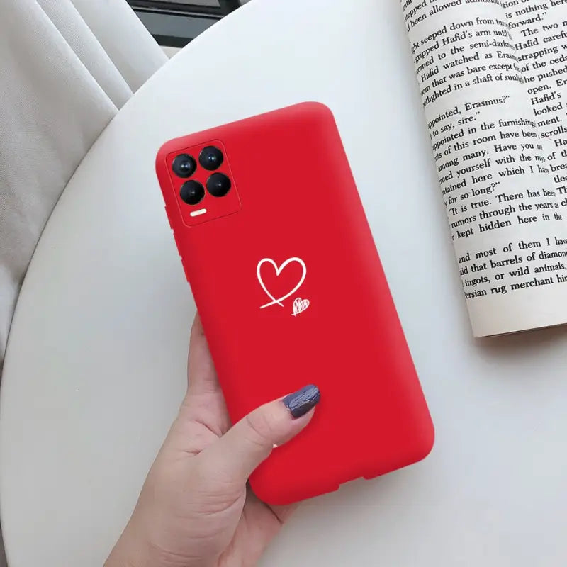 a woman holding a red phone case with a heart on it