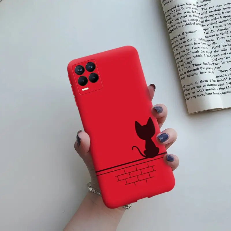 a woman holding a red phone case with a cat on it