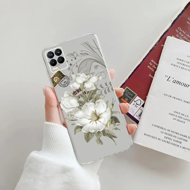 a woman holding a phone case with flowers