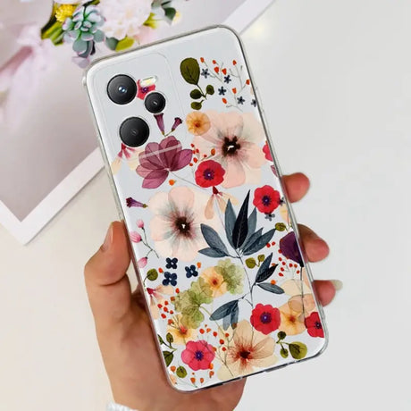 a woman holding a phone case with flowers on it