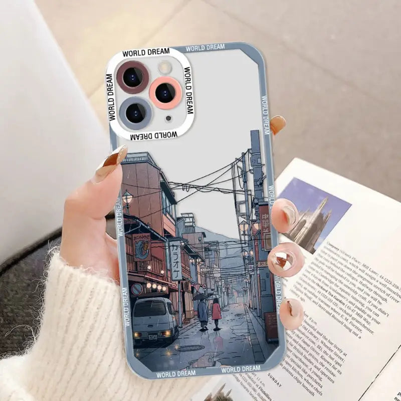 a woman holding a phone case with a photo of a street scene