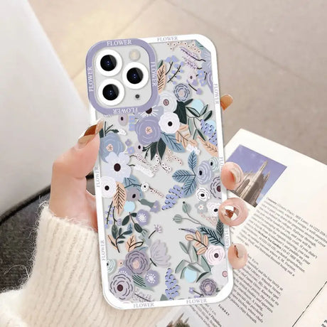 a woman holding a phone case with flowers on it