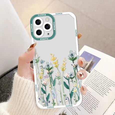 a woman holding a phone case with flowers on it