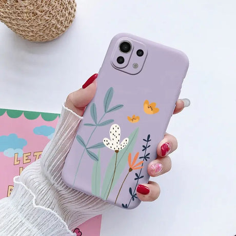 a woman holding a phone case with flowers on it