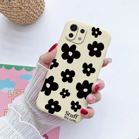 a woman holding a phone case with a flower design