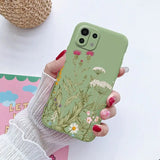 a woman holding a phone case with flowers on it