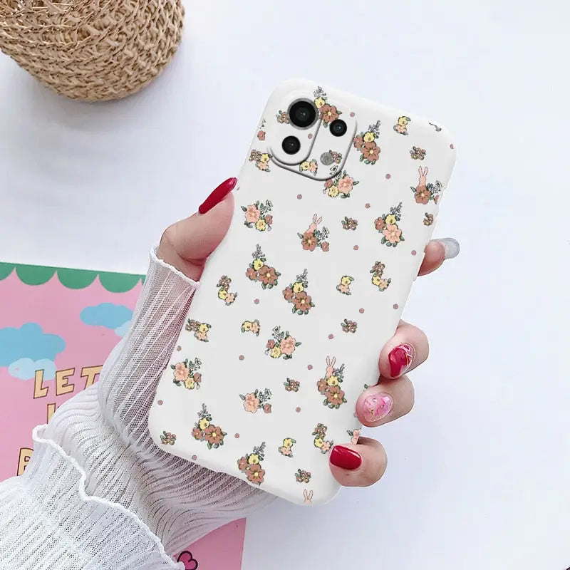 a woman holding a phone case with a flower pattern