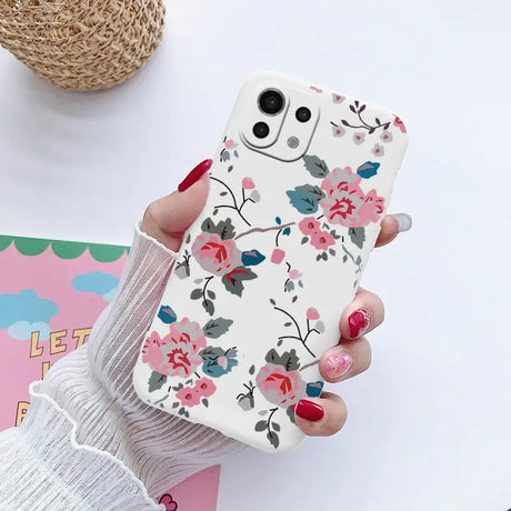 a woman holding a phone case with flowers on it