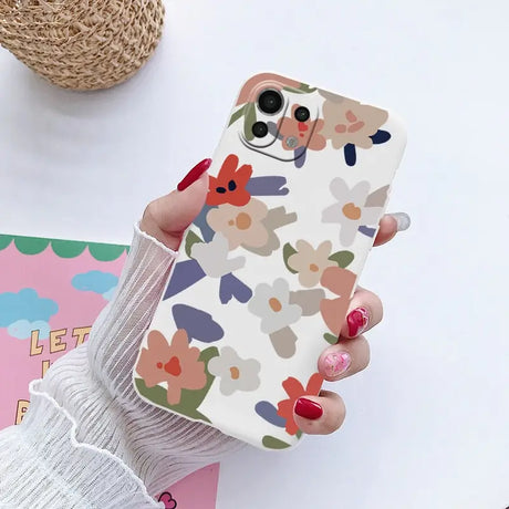 a woman holding a phone case with colorful hearts on it