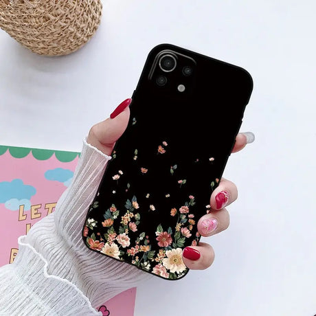 a woman holding a phone case with flowers on it