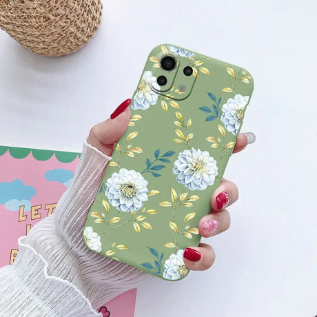 a woman holding a phone case with flowers on it