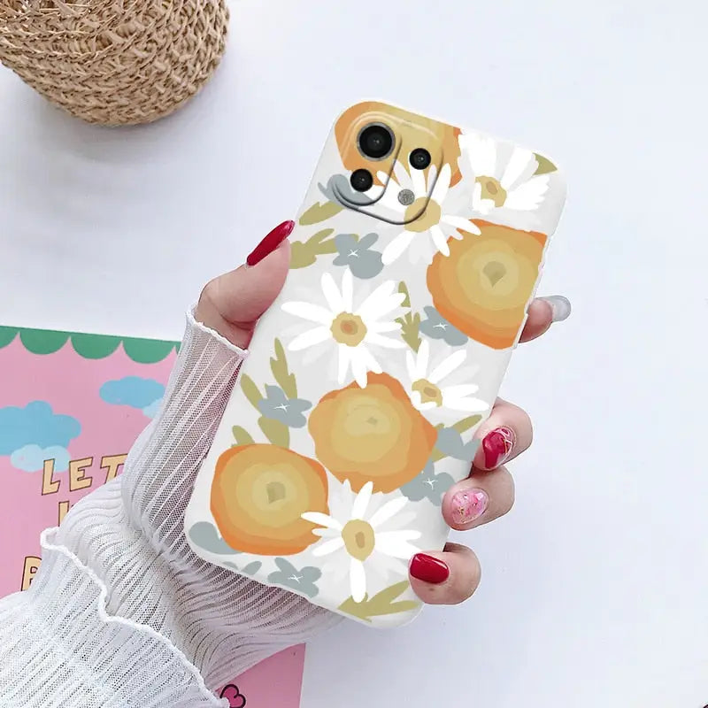 a woman holding a phone case with a pattern of oranges