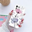 a woman holding a phone case with flowers on it