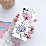 a woman holding a phone case with flowers on it