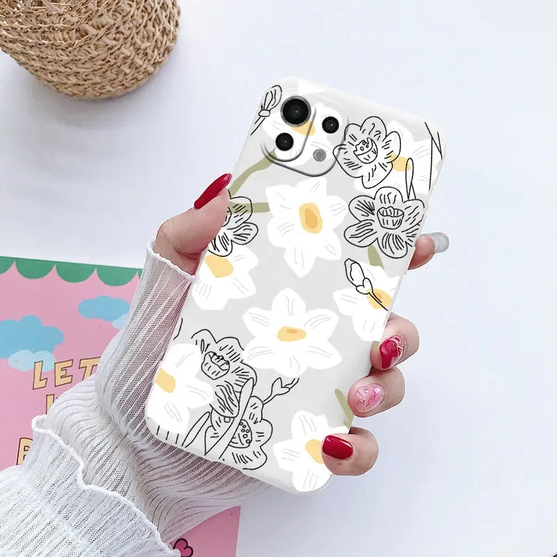 a woman holding a phone case with a flower pattern