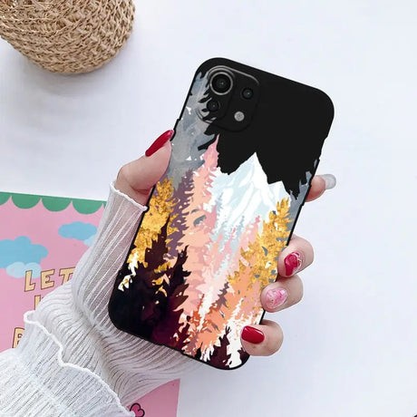 a woman holding a phone case with a painting on it