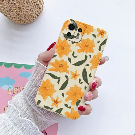 a woman holding a phone case with flowers on it