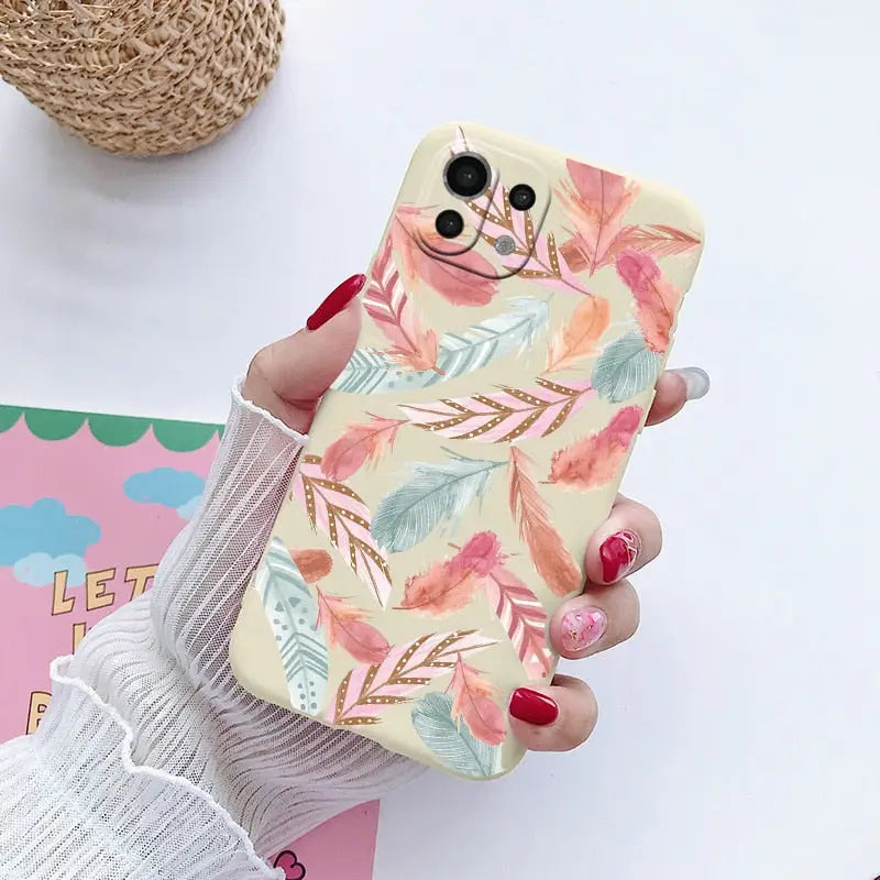 a woman holding a phone case with a floral pattern