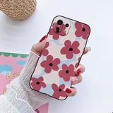 a woman holding a phone case with a flower pattern