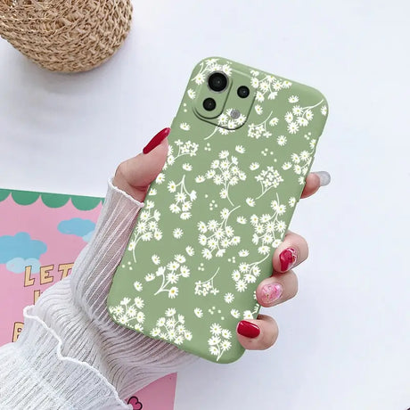 a woman holding a phone case with a flower pattern