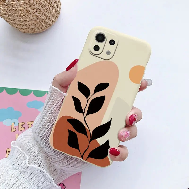 a woman holding a phone case with a plant on it